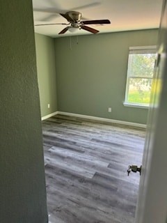 A room with a ceiling fan and a door.