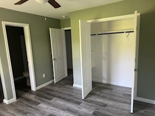 Three white doors are open in a room with wood flooring.