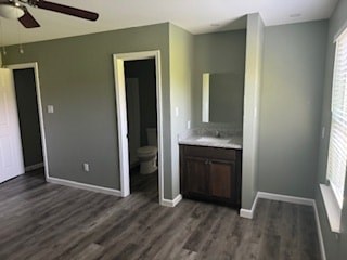 A bathroom with a wooden floor and a white vanity.