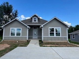 A house with a grey siding and a brown roof.