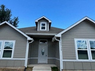 A house with a grey front and a white door.