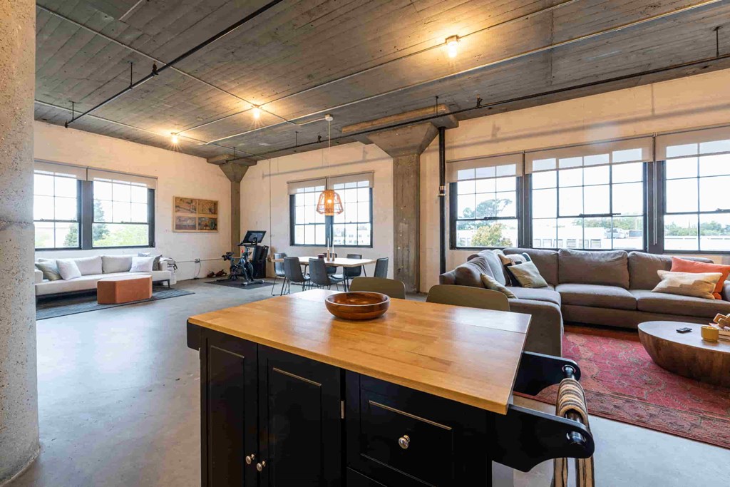 the living room of a loft with a kitchen and couches