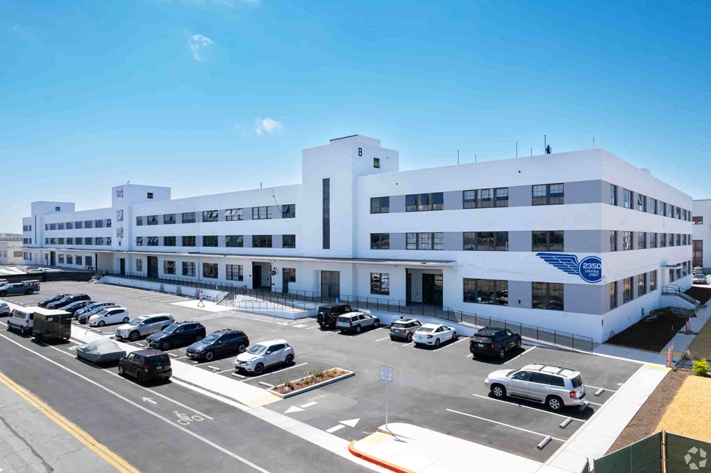 a large white building with cars parked in a parking lot