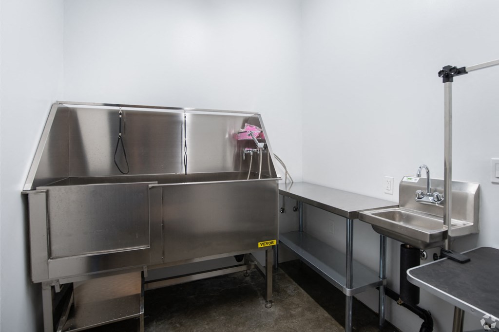 a commercial stainless steel kitchen with two sinks and a mixer
