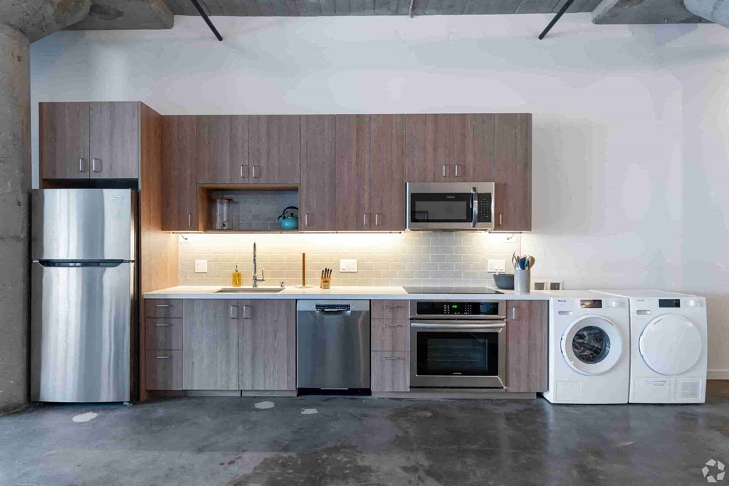 a kitchen with a washing machine and a refrigerator