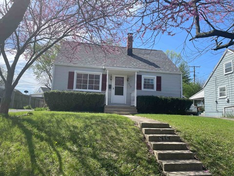a small white house with stairs in front of it