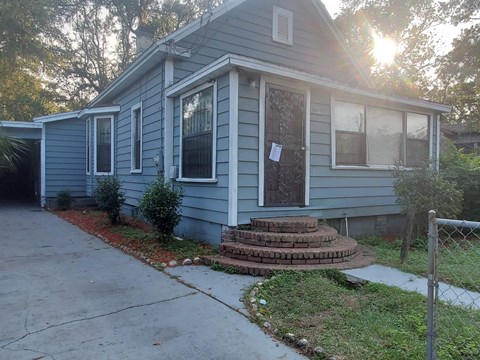 a blue house with a sidewalk in front of it