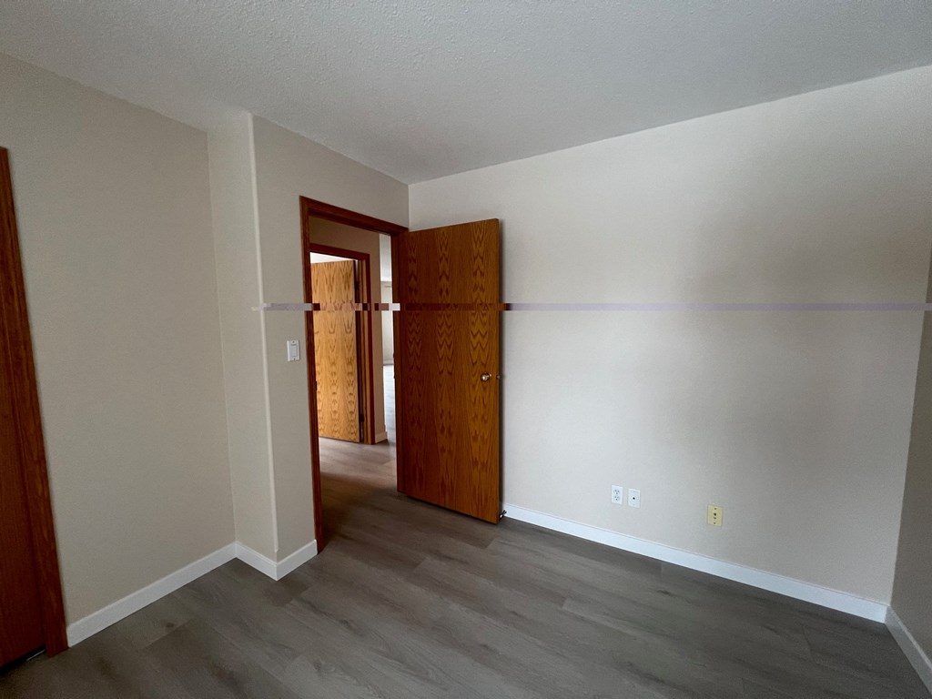 an empty living room with white walls and wood flooring
