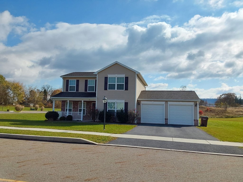a house with a driveway and a cloudy sky