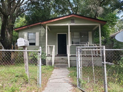 A small house with a fence in front of it.