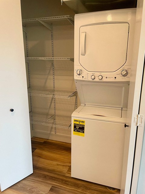 a walk in closet with a washer and dryer