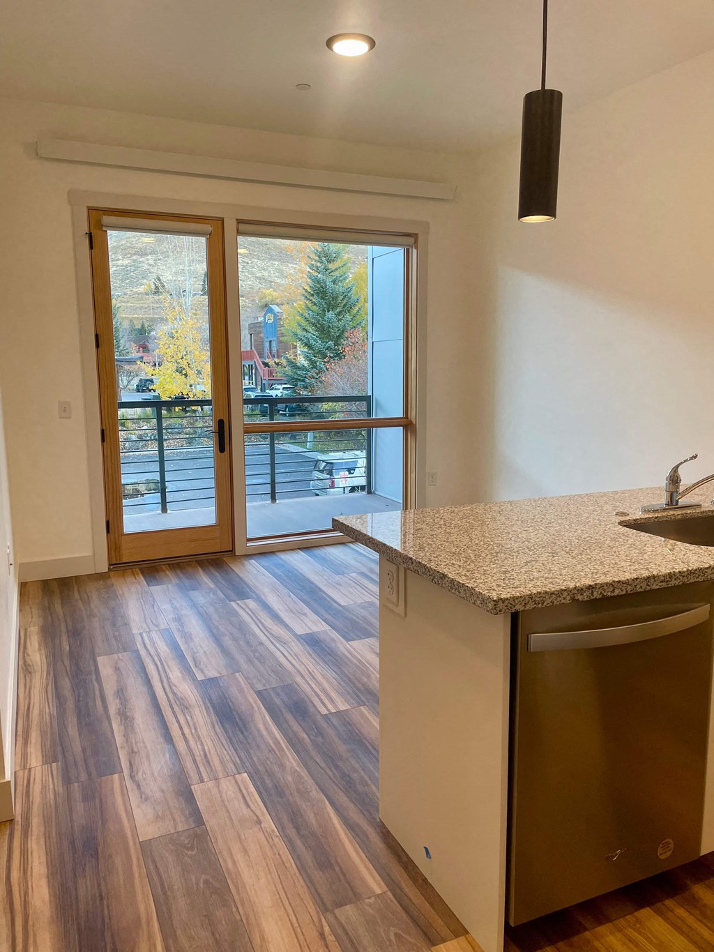 a kitchen with a sink and a door to a balcony