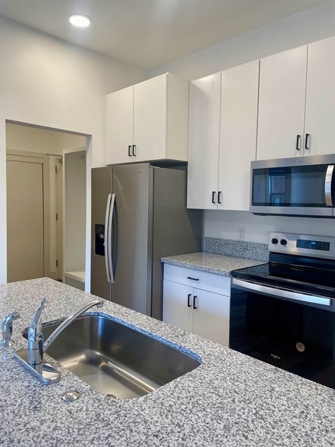 a kitchen with granite counter tops and stainless steel appliances