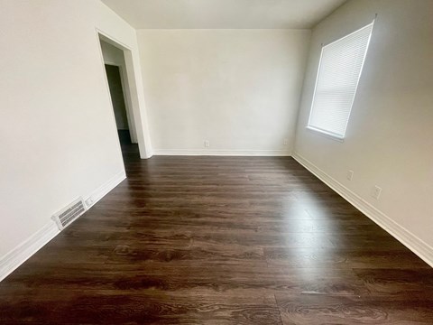 an empty room with wood floors and white walls