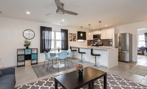 a living room with a kitchen and a table and chairs