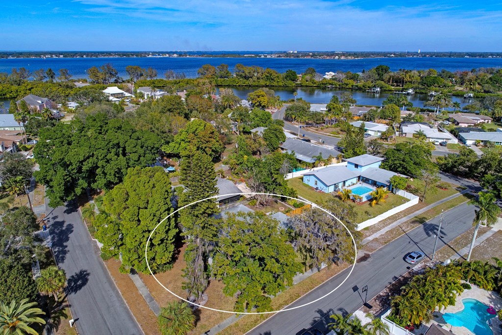 an aerial view of a neighborhood with a body of water in the background