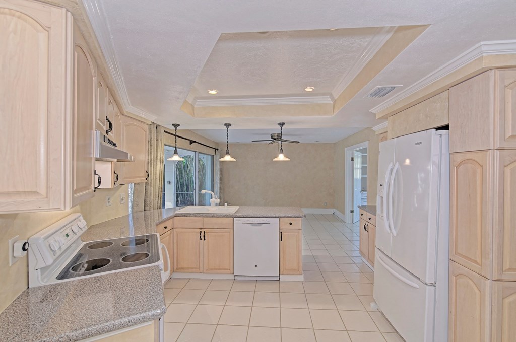a kitchen with white appliances and wooden cabinets