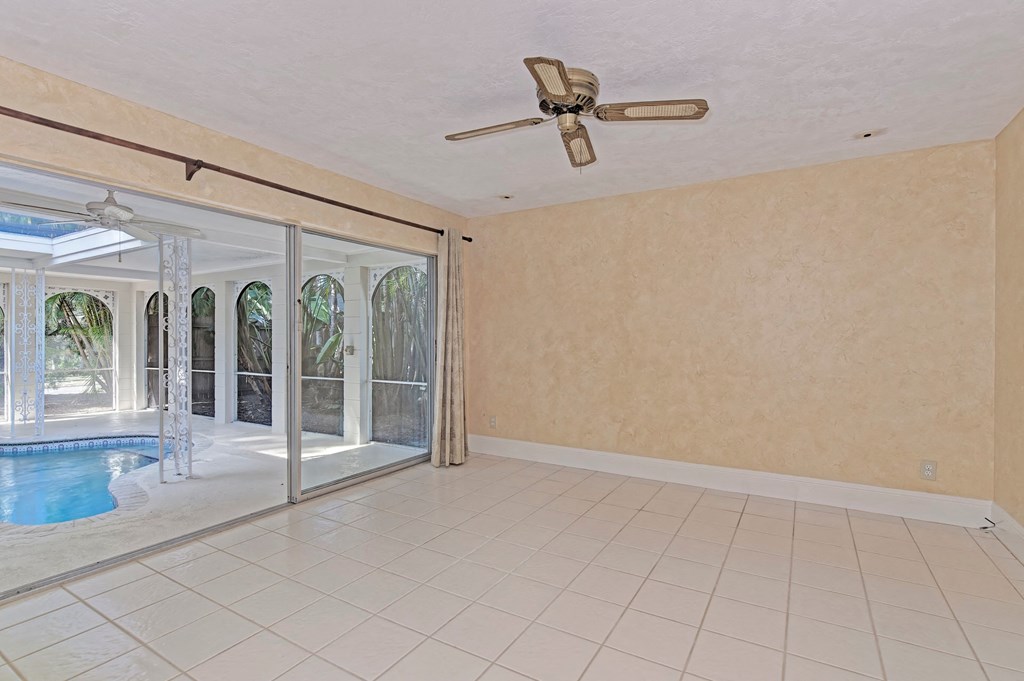 an empty living room with a pool and a ceiling fan