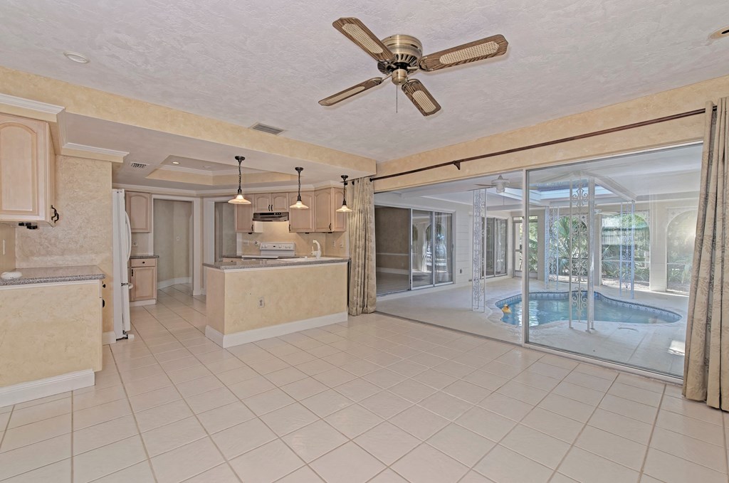 a large living room with a pool and a ceiling fan