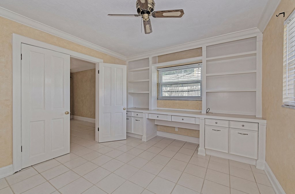 a laundry room with white cabinets and a window