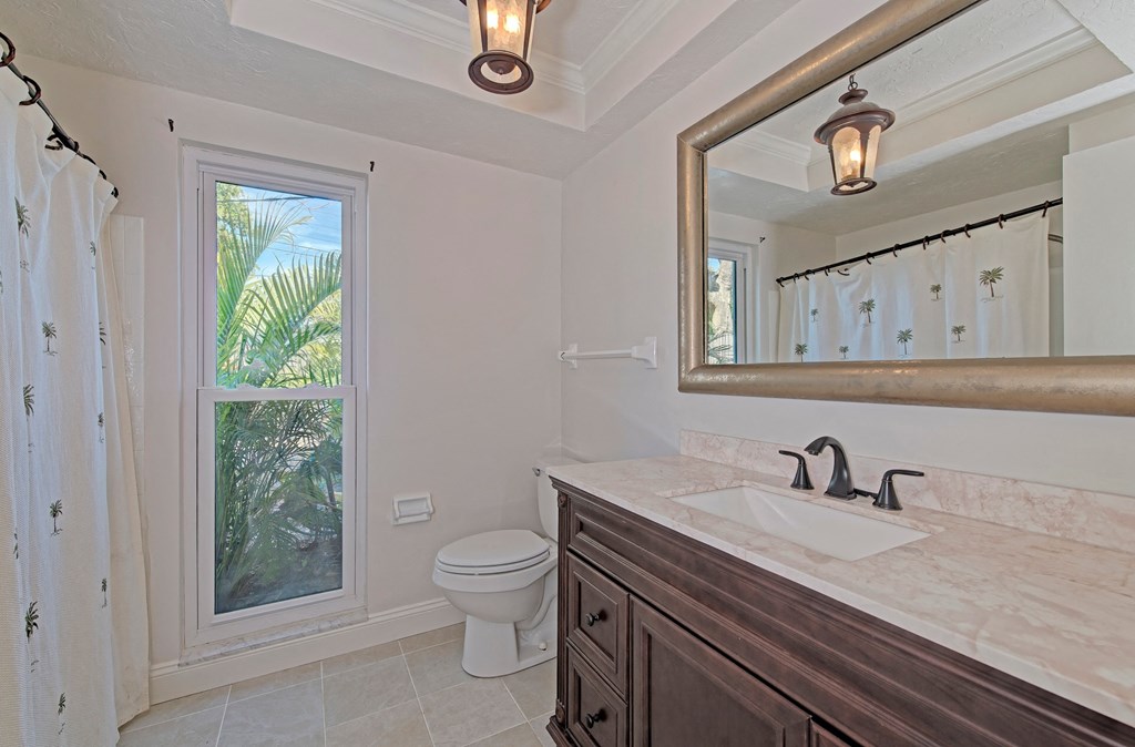 a bathroom with a large window and a sink and a toilet