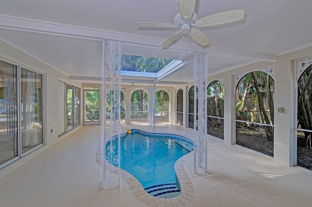a swimming pool in the middle of a room with a ceiling fan