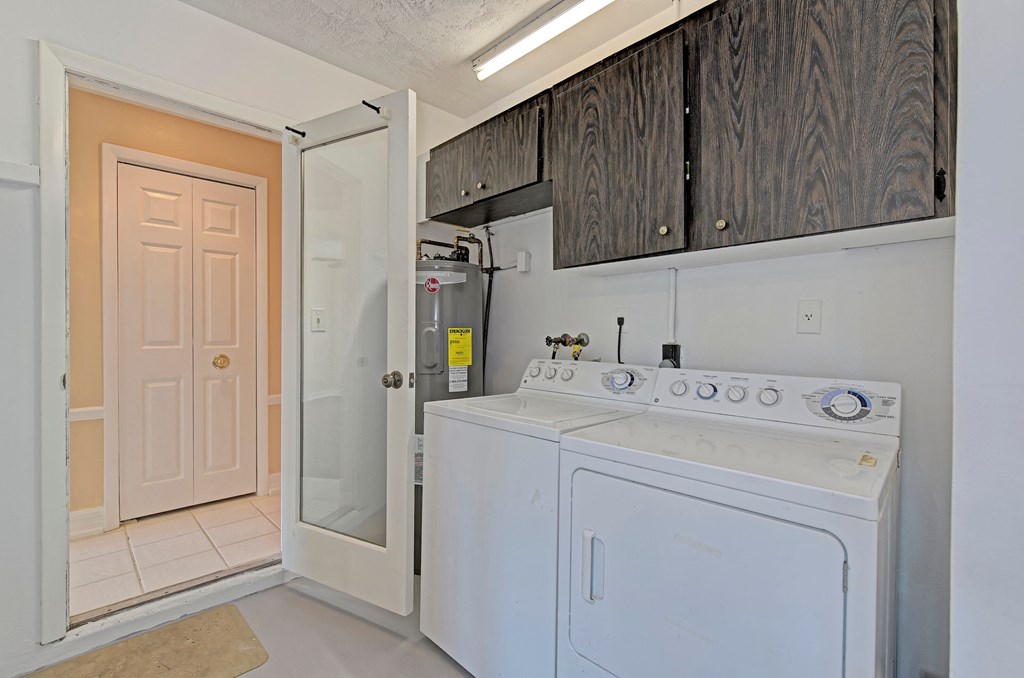 a white washer and dryer in a laundry room with a door to a