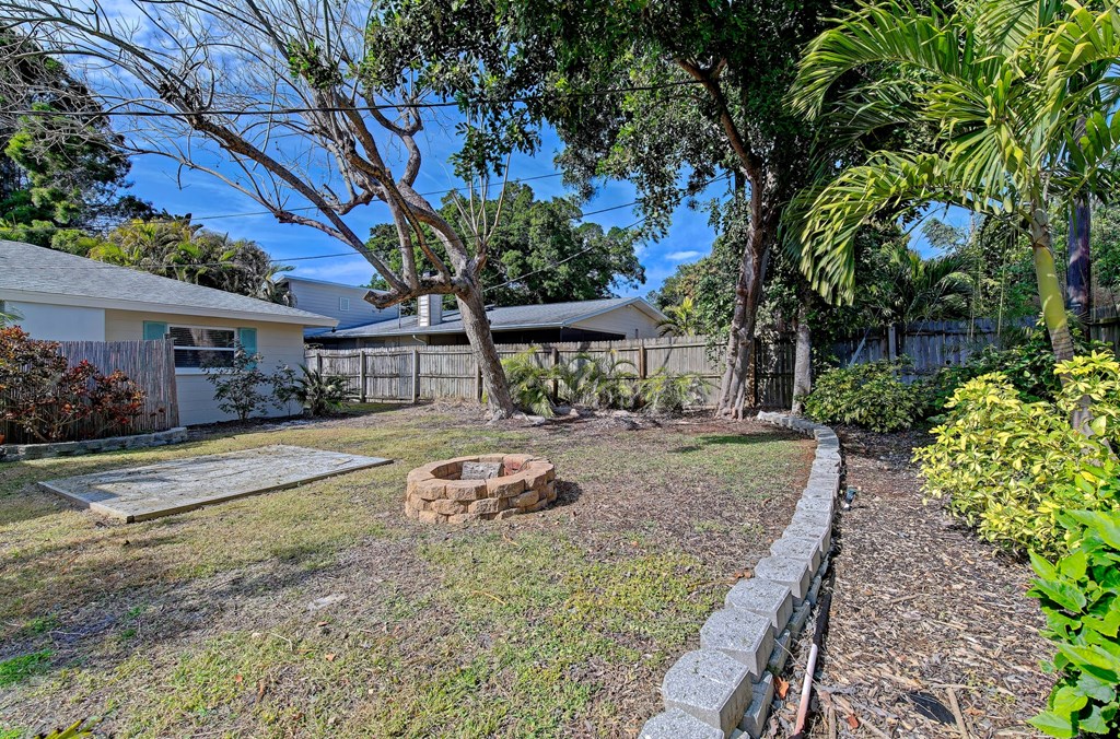 a backyard with a fire pit and a fence