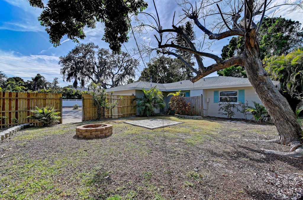 a yard with a house and a fence and a tree