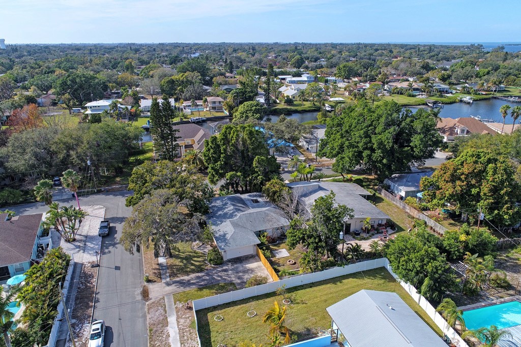 an aerial view of a neighbourhood with trees and a river