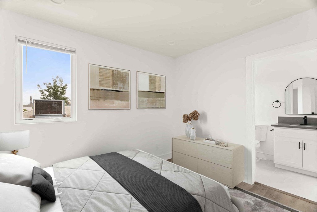 a white bedroom with a bed and a window