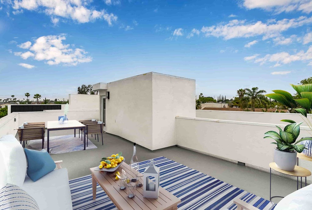 a furnished balcony with a table and chairs and a view of the ocean