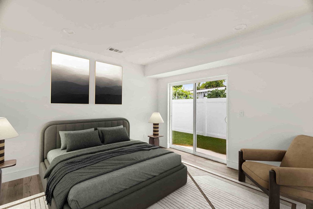 a bedroom with a bed and a chair and a sliding glass door