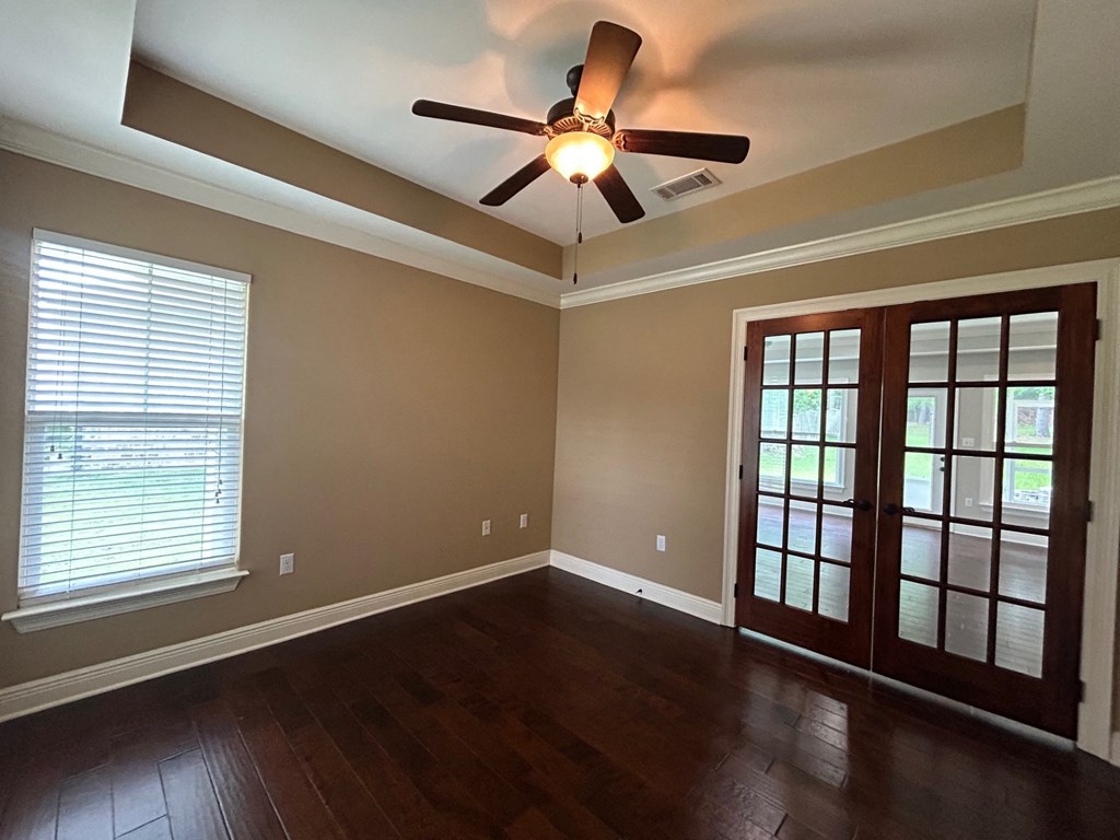 an empty living room with a ceiling fan and a window