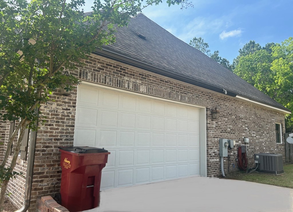 the side of a brick garage with a white garage door