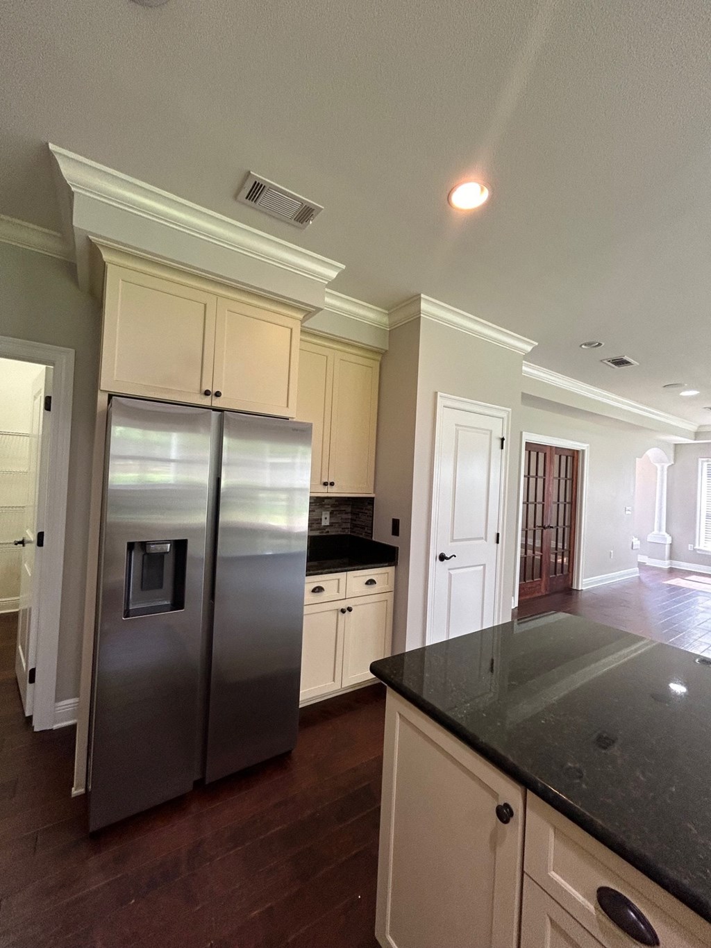 a kitchen with a stainless steel refrigerator and white cabinets