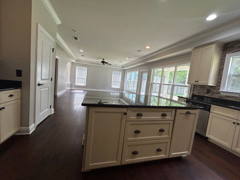 a kitchen with white cabinets and a black counter top