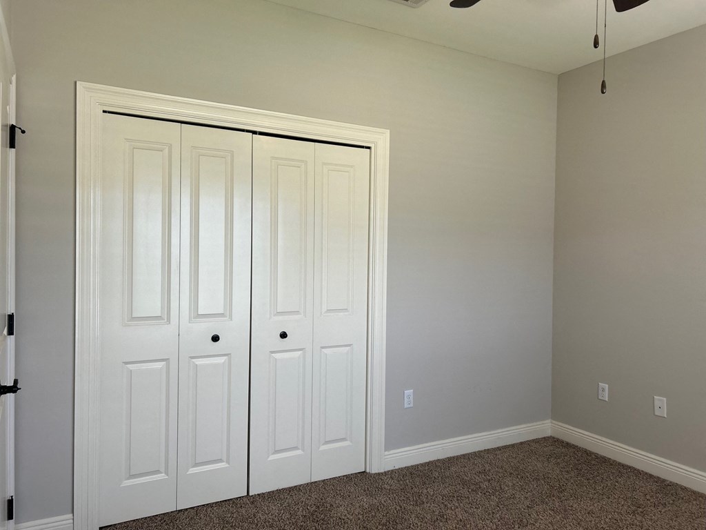a bedroom with two closets and a carpeted floor