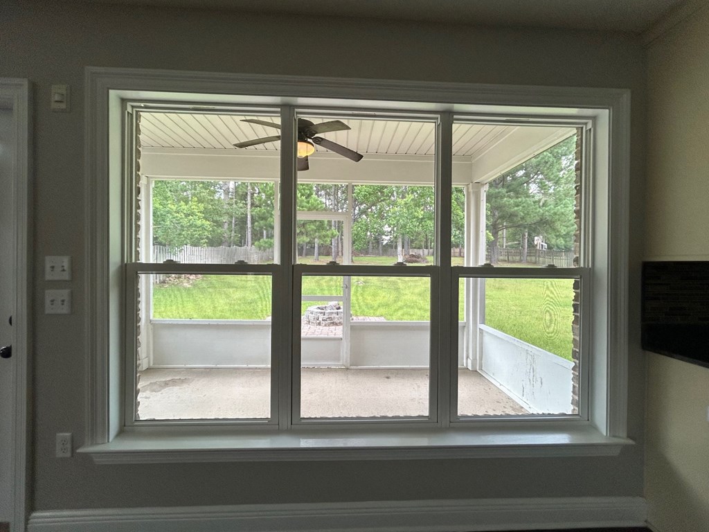 a large window in a room with a view of a backyard