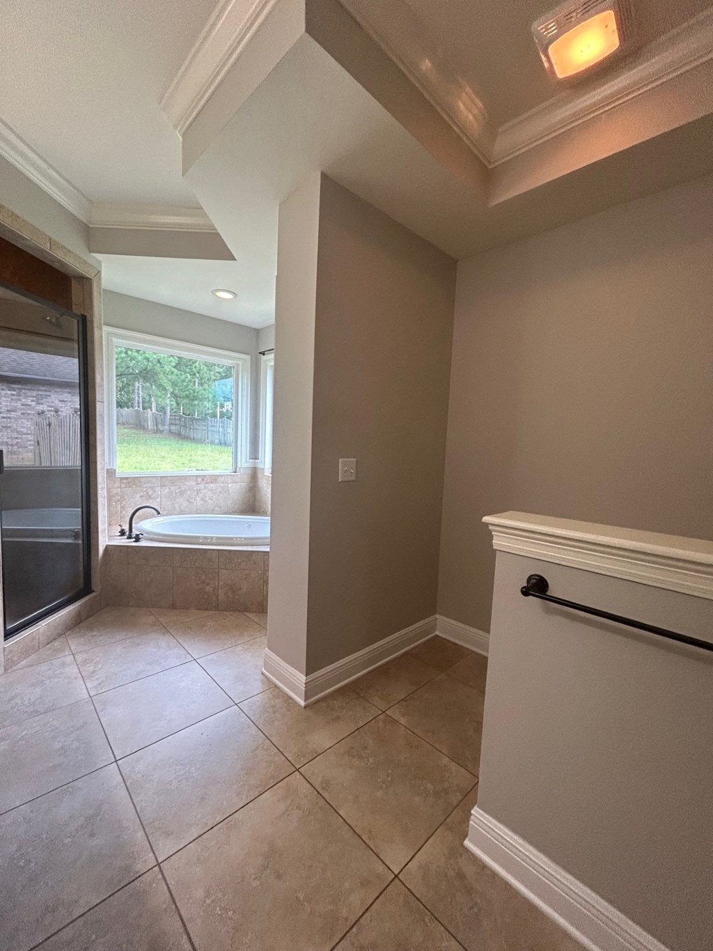 a large bathroom with a tub and a shower and a window