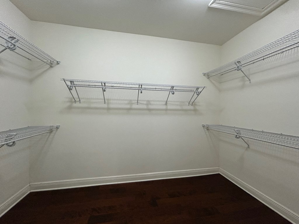 a walk in closet with shelves and hanging racks