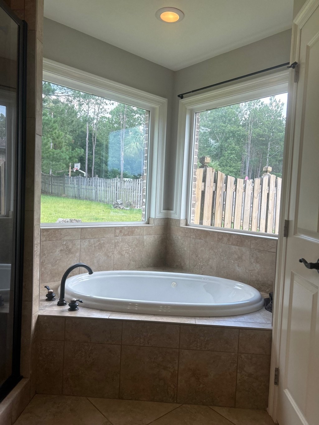 a large white bath tub in a bathroom with a window