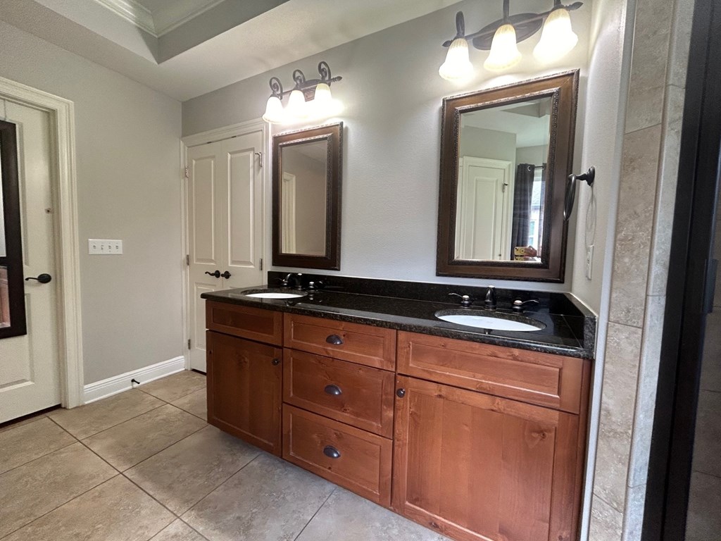 a large bathroom with two sinks and two mirrors