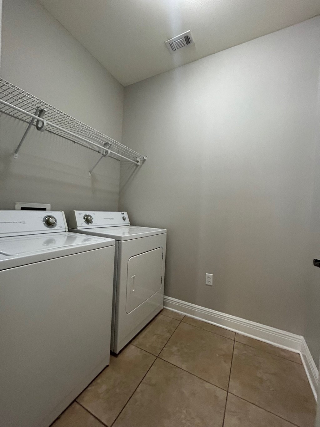 an empty laundry room with two washes and a dryer