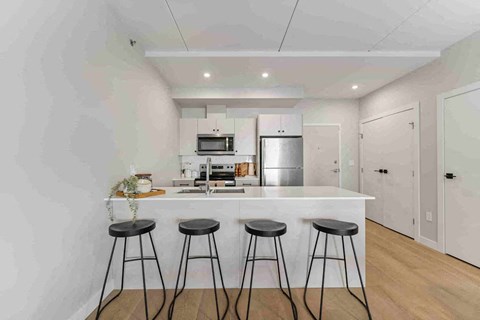 A kitchen with a bar stool in front of it.
