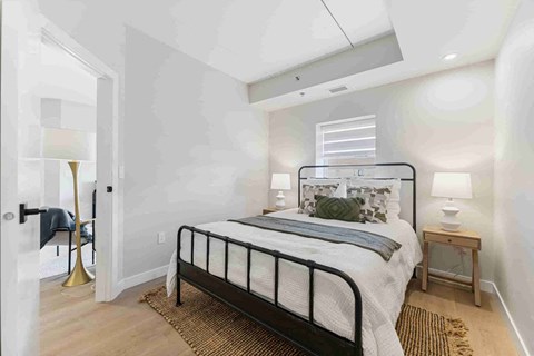 A bedroom with a bed, nightstand, and lamp.
