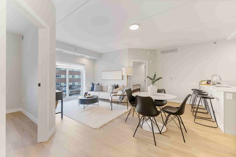 A modern living room with a dining area and kitchenette.
