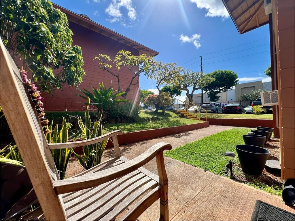 a patio with a wooden bench in a backyard