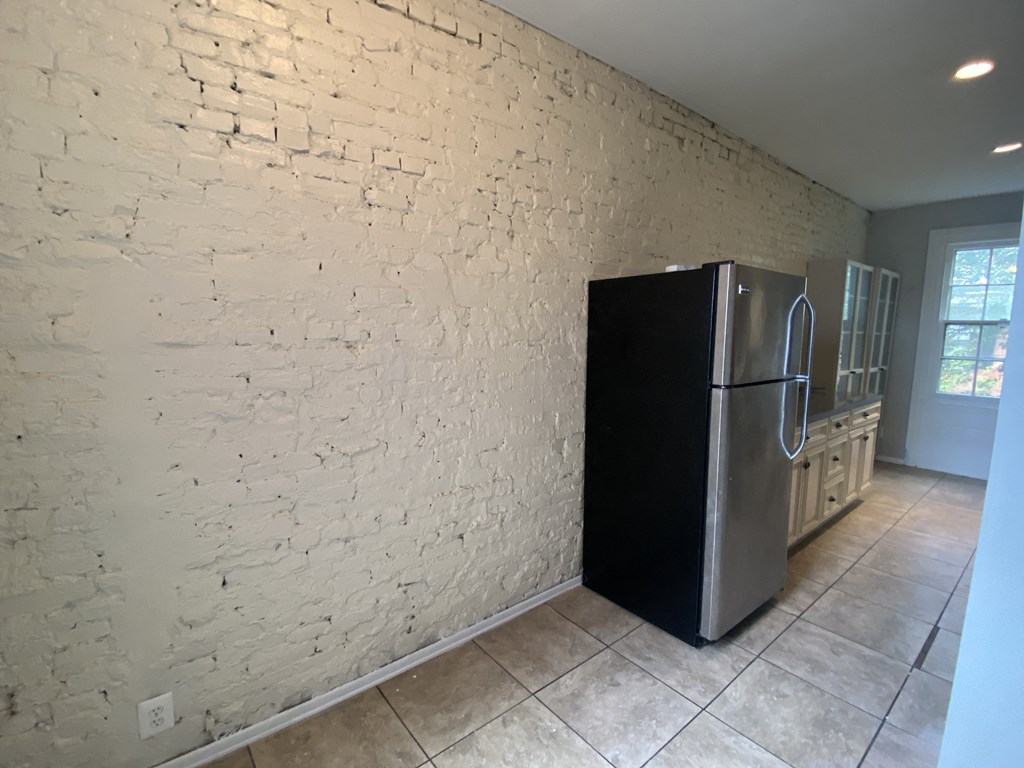 a white brick wall in a kitchen with a refrigerator