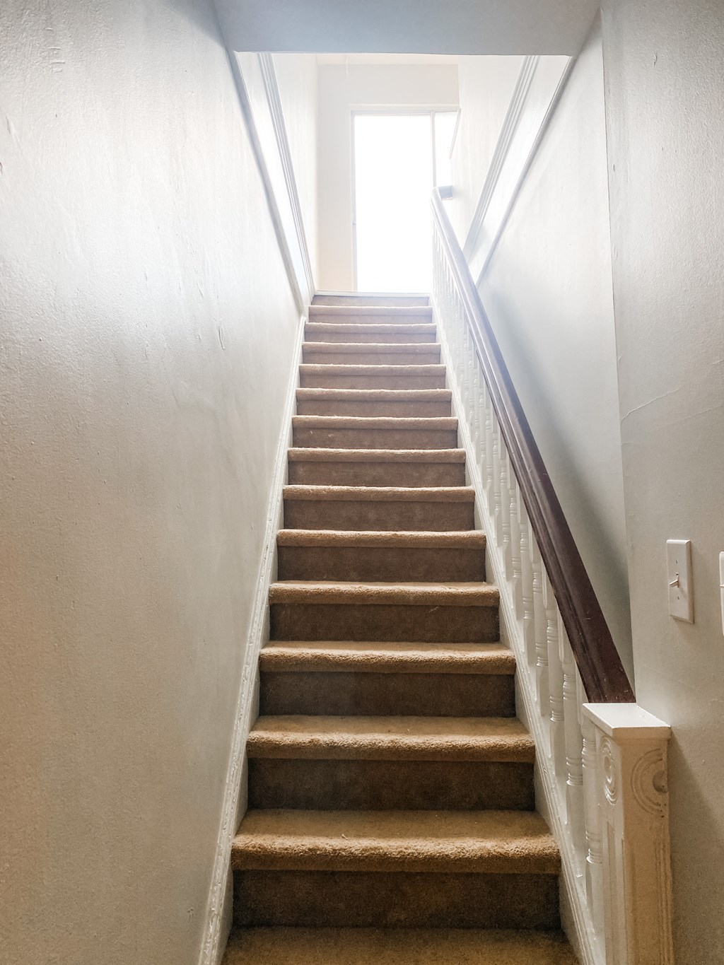a flight of stairs with a window at the top